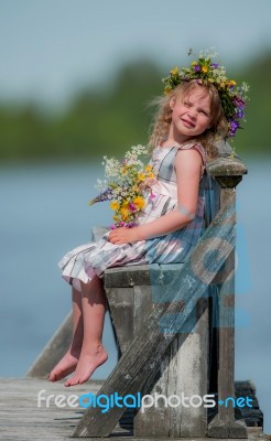 Little Girl Sitting On A Bench Stock Photo