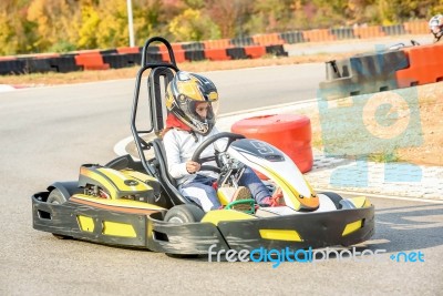 Little Girls Are Driving Go- Kart Car In A Playground Racing Track Stock Photo