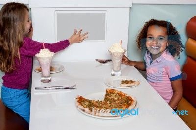 Little Girls Enjoying Pizza In A Restaurant Stock Photo