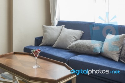 Luxury Blue Sofa With Grey Pillows And Wooden Table Stock Photo