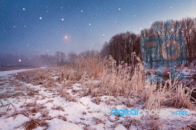 Magic Winter Christmas Night. Snowfall Scene On A River Stock Photo