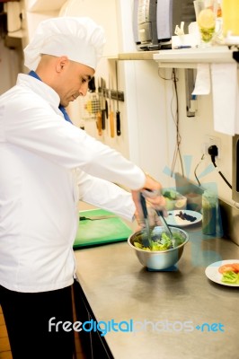 Male Chef Busy In Giving Final Touch To Recipe Stock Photo