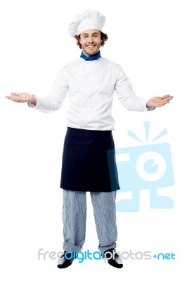 Male Chef In Uniform Welcoming Guests Stock Photo