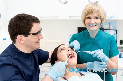Male Dentist Treat The Female Patient Stock Photo