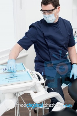 Male Dentist With Tools At Dental Office Stock Photo