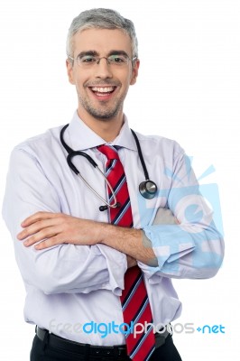 Male Doctor Smiling With Arms Crossed Stock Photo