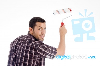 Male Looking Backward While Using Roller Brush Stock Photo
