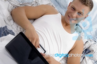 Male Using Laptop On His Stomach Stock Photo