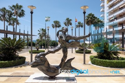 Man Above Dolphin Statue By Salvador Dali In Marbella Stock Photo