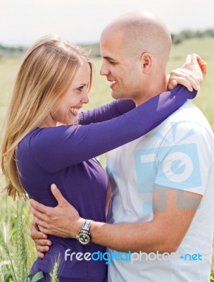 Man And Woman Embracing In Field Stock Photo
