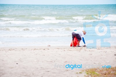 Man Cleaning Rubbish At Beach Stock Photo