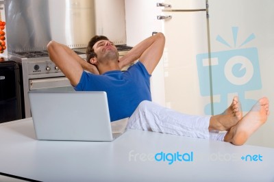 Man In Kitchen With Laptop Stock Photo