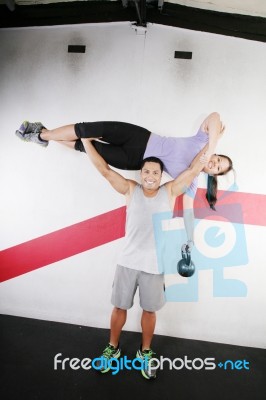 Man Lifting A Woman At Gym Stock Photo