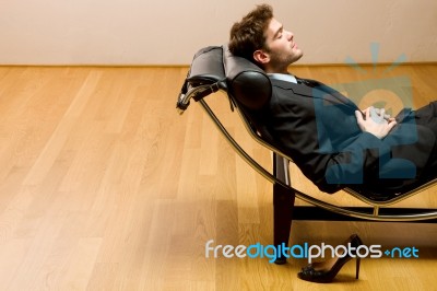 Man Lying On Chaise Longue Stock Photo