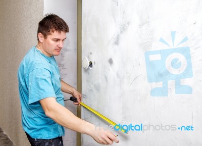 Man Measuring The Wall With A Tape Measure Stock Photo