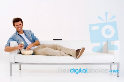 Man On Sofa Watching TV With Remote Stock Photo