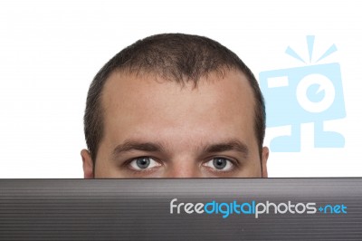 Man Peeking Over Laptop Stock Photo