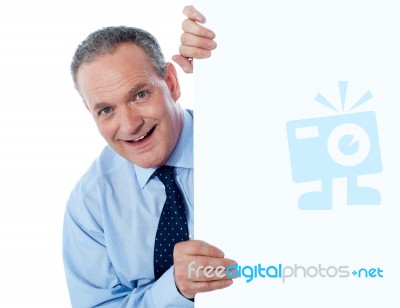 man Peeping Behind Empty board Stock Photo