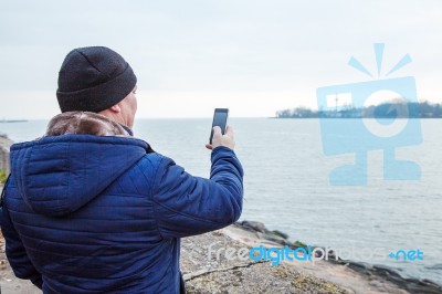 Man Photographing Seascape By Mobile Phone Stock Photo
