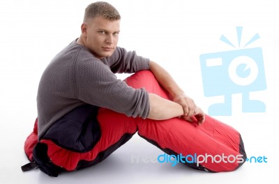 Man Sitting With Sleeping Bag Stock Photo