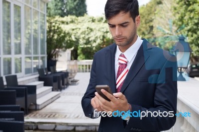 Man Using A Smart Phone On The Street Stock Photo