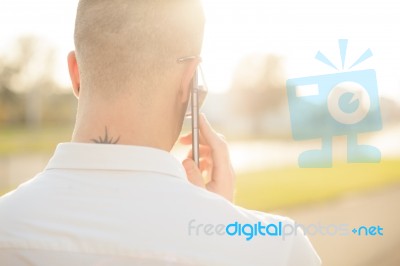 Man With Mobile Phone In Hands, Back View, Outdoor Stock Photo