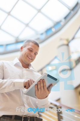 Man With Tablet Computer In Modern Business Building Stock Photo