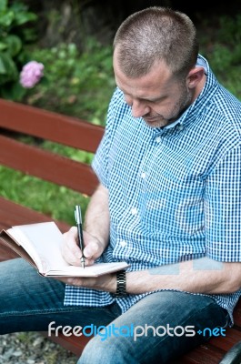 Man Writing In Notepad Stock Photo