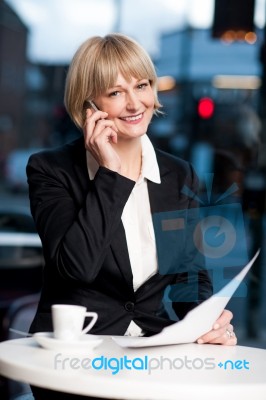 Manager Communicating Via Cell Phone In Cafe Stock Photo