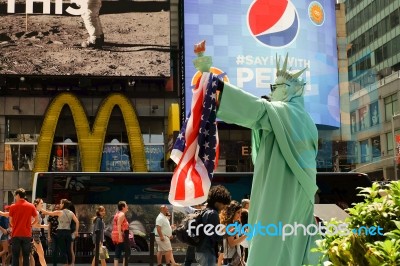 Manhattan, New York - June, 2016 Living Statue Man Performance As Statue Of Liberty With American Flag At Times Square For Celebrate Before Independence Day Of The United States, July 4th Stock Photo