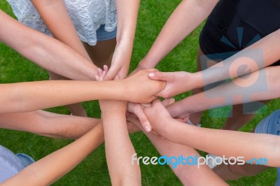 Many Arms Of Children Holding Hands Together Stock Photo