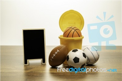 Many Kind Of Balls And Yellow Basket With Blank Black Board Stock Photo