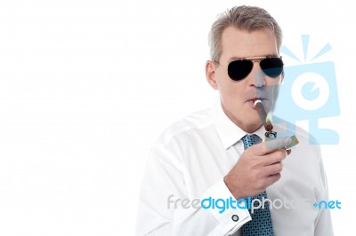 Mature Businessman Smoking A Cigar Stock Photo