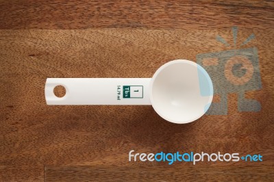 Measuring Spoon On Wooden Background Stock Photo