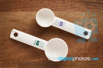 Measuring Spoons In Varying Sizes On Wooden Background Stock Photo