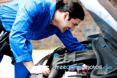 Mechanic Checking Under The Car Engine Stock Photo