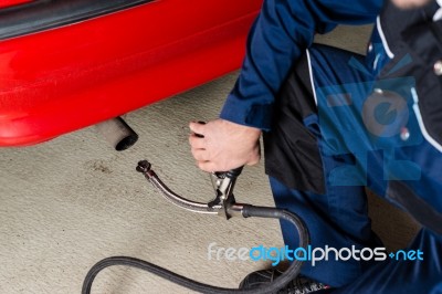 Mechanic Measuring Exhausts Of A Car In Garage Stock Photo