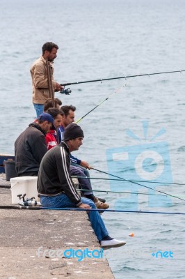 Men Fishing Off The Quayside At The Harbour In Funchal Stock Photo