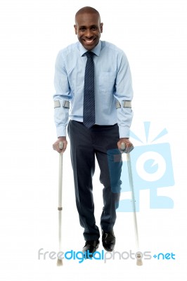 Middle Aged Man Walking With Two Crutches Stock Photo