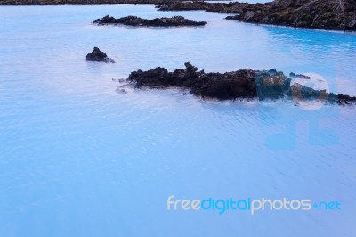 Milky White And Blue Water Between The Lava Stones Covered With Moss Stock Photo