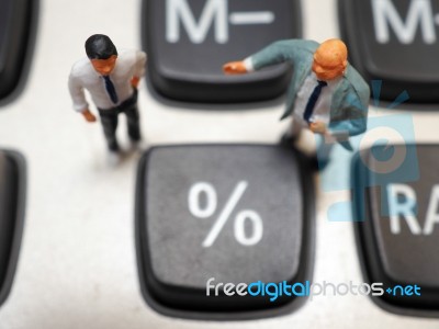Miniature Businessman Standing On Calculator And Thinking Of Per… Stock Photo