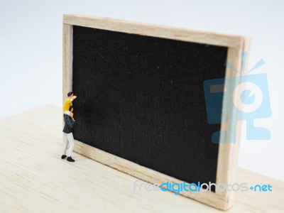 Miniature Children Standing In Front Of A Blackboard On Wooden B… Stock Photo