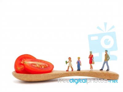 Miniature Children Standing On Fresh Grape Or Cherry Tomato With… Stock Photo