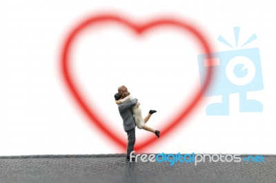 Miniature Couple Hugging On White Background Stock Photo