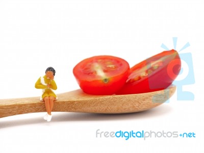 Miniature Woman Sitting On Fresh Grape Or Cherry Tomato With Woo… Stock Photo