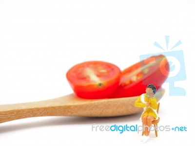 Miniature Woman Sitting On Fresh Grape Or Cherry Tomato With Woo… Stock Photo