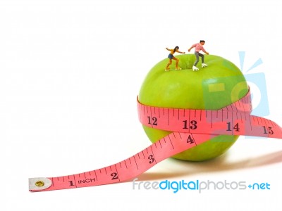 Miniature Woman Skating On Green Apple And Measuring Tape , Thin… Stock Photo