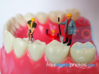 Miniature Worker On Plastic Teeth Of Removable Denture. Dental H… Stock Photo