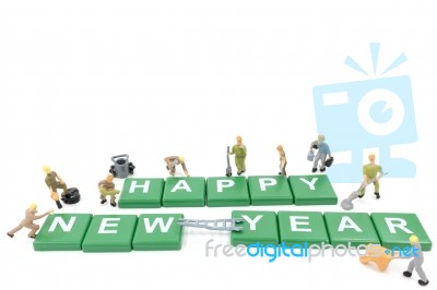 Miniature Worker Team Building Word Happy New Year On White Background Stock Photo