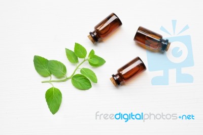 Mint Essential Oil In A Glass Bottle With Leaves On White Backgr… Stock Photo